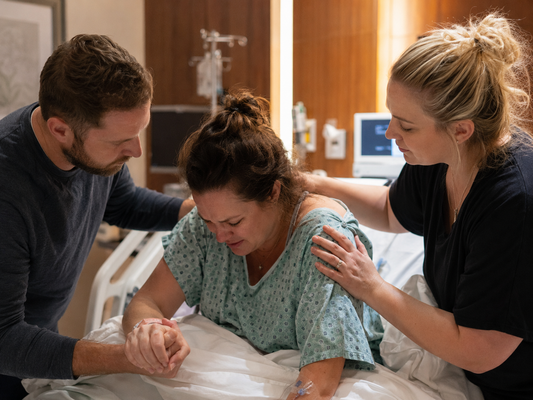 Birth doula supporting a laboring mother alongside her partner